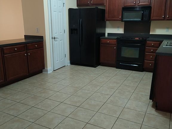 Large Kitchen with tile floor, black appliances, and pantry