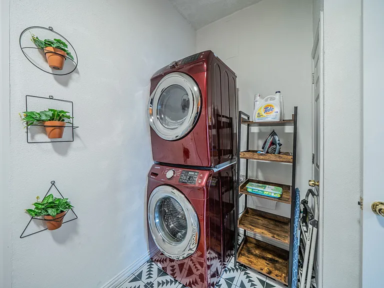 In-unit laundry with a modern stacked washer and dryer.