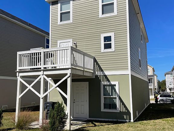 back of house with deck off kitchen and brick patio below