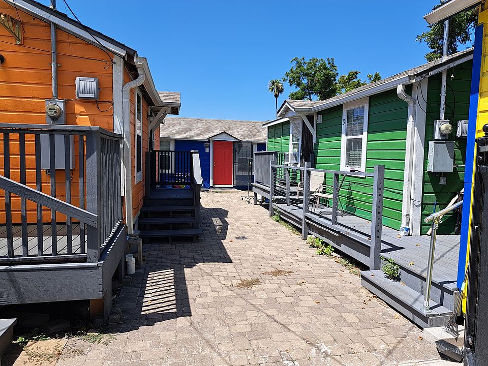 Gate entry to courtyard. Available unit is Blue building in back, with Red Door.