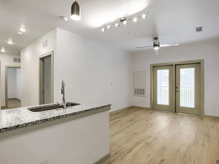 living room with kitchen and hallway in the background