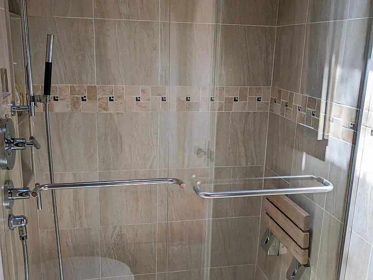 Low curb shower with fold-up teak seat