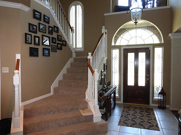 Two Story Entry with a leaded Glass Front Door with Arched Window and Sidelights. All of the Windows Have Solar Screens Except Across the Front of the Home!