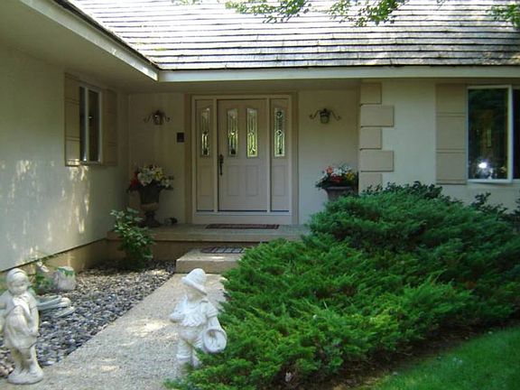 This front entrance, framed by nature, says "welcome home." Maintenance free durable "stucco" look e