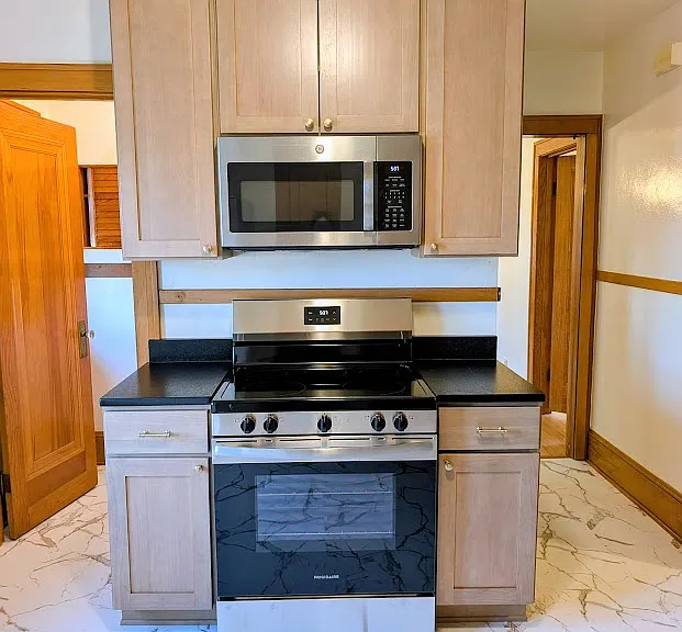 [UPPER UNIT]: Newly remodeled kitchen with stainless steel appliances, leathered granite countertops, solid wood cabinets, luxury vinyl tile flooring with Carrara Marble aesthetic, champagne gold fixtures