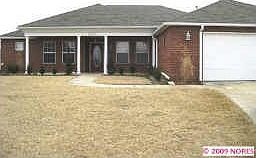 front view of red brick home with white columns