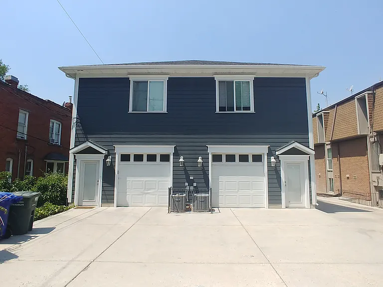 Back View of the building from the Parking area. One Car Garage included plus dedicated parking space