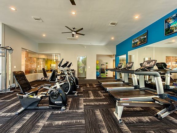 Fitness club with cardio and weight training equipment, free weights, and television monitors.