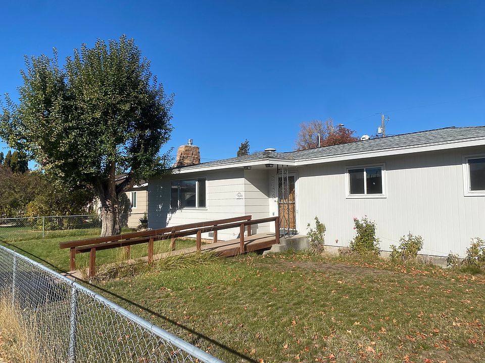 Front entry with walkway ramp and fenced front yard.