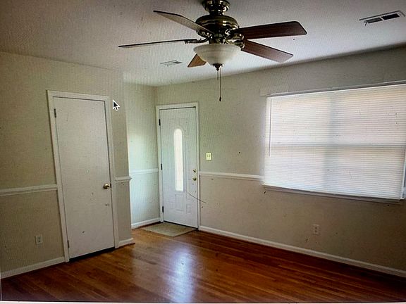 Living room area with hard wood floors: Front door and coat closet door