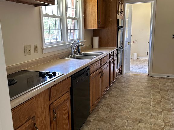 kitchen with downdraft cooktop, dishwasher and double ovens