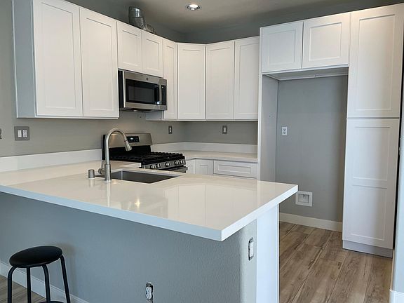 Kitchen with Quartz Counters and white Shaker cabinets. New Stainless Steel appliances.