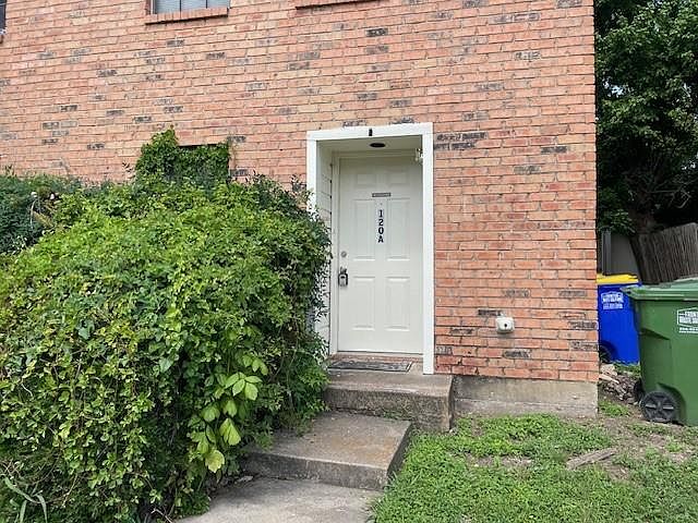 Doorway to property featuring brick siding