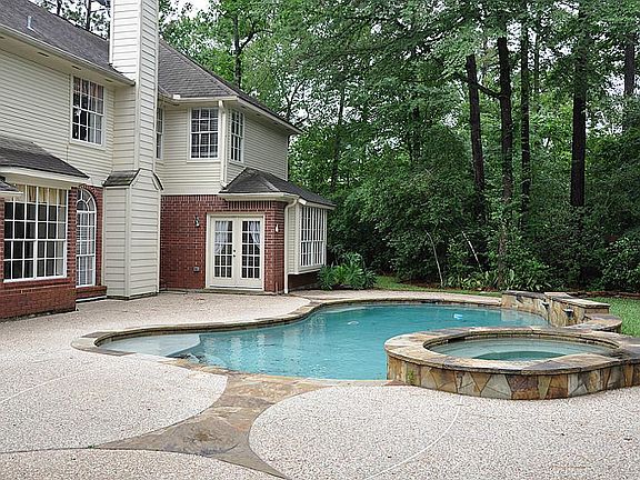 This view of the backyard shows the double French doors from the master bedroom and the generous pat