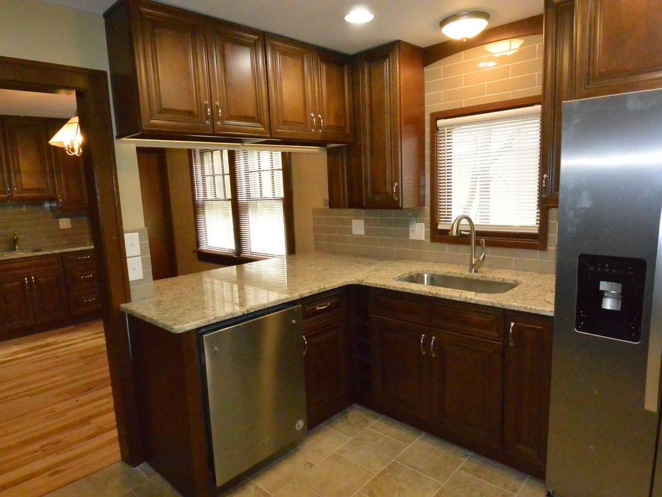 Remodeled kitchen with oversized granite counter tops, tiled floor, tiled back splash, large single bowl sink and Whirlpool stainless appliances.
