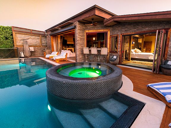 Pool deck looking back at the home. Master Bedroom to the right, Bar area straight ahead and great room to the left.