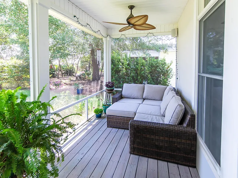 Screened in backyard porch with two fans is perfect for enjoying the outdoors.
