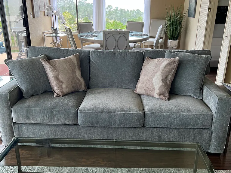 Cozy comfortable new fold out sofa bed adjacent from large 55" screen Smart TV and fireplace.