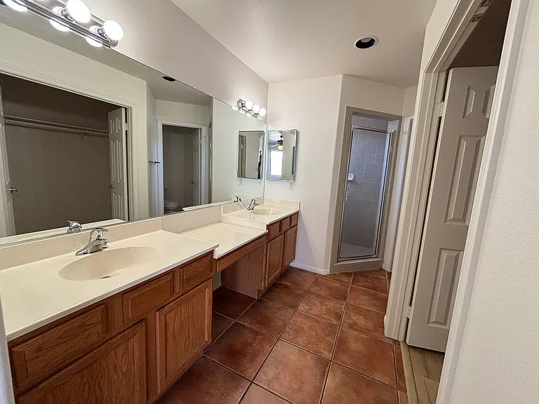Primary bathroom with dual sinks, generous counter space, and ample storage.