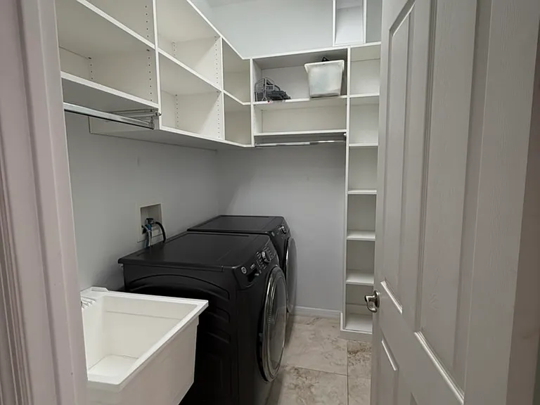 downstairs laundry room showing laundry shoot (connected from the primary bathroom) and closet system
