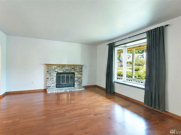 Living room has a bay window and wood burning fireplace