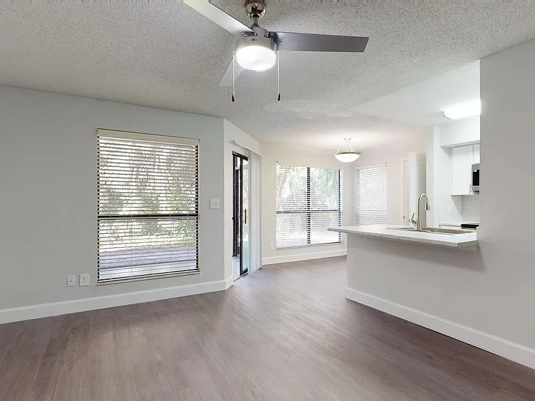 The Martinique floor plan offers a spacious open-concept living and dining area with large windows, modern lighting, and access to a private patio.