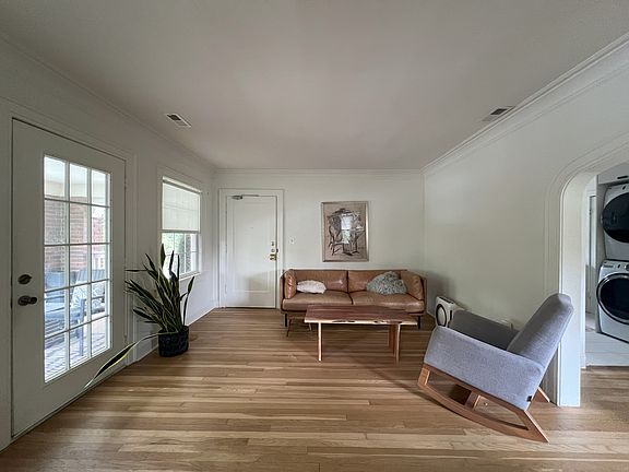 Extra wide living room for watching Chiefs game, setting up bonus lounge or office space. Front door to apartment and balcony door are in this view.