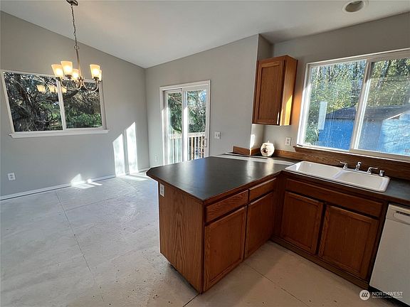 The kitchen with eating bar spreads into the dining area, creating a perfect space for gathering and entertaining.>