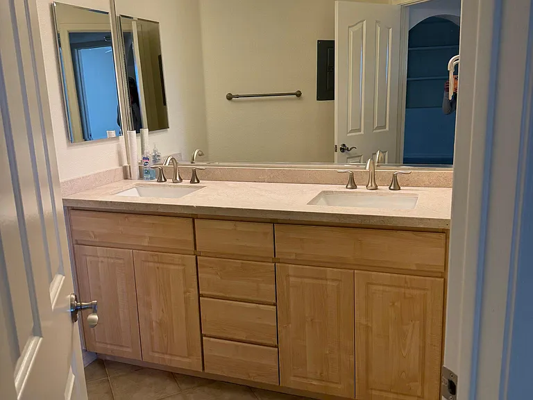 Bathroom is spacious with lots of storage and new countertops, faucets, and sinks.