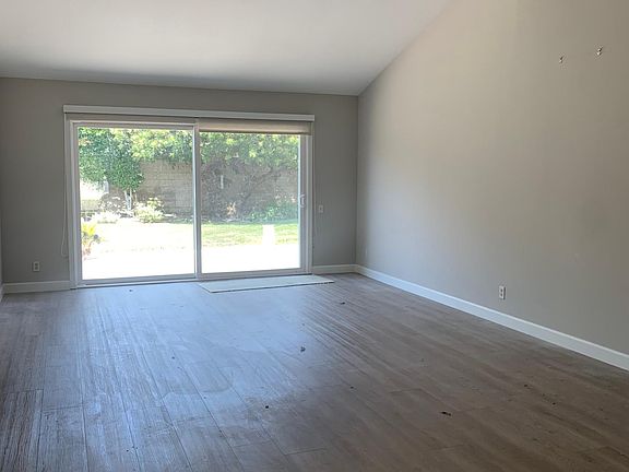 Main living room with cathedral ceilings, large slider to grassy backyard