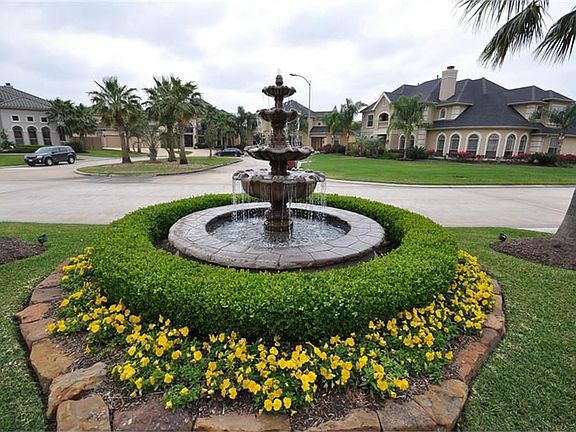 Gorgeous 4-tier fountain surrounded by tasteful landscaping and florals in the front yard!