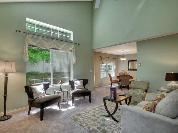 Great room feel for this living room with vaulted ceilings! open into dining room, and private patio