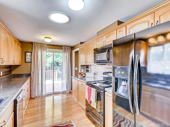 Gallery style kitchen, remodeled, leading to the back deck and dining area.