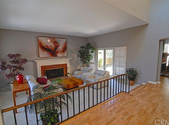 Spacious step down living room with beautiful fireplace and french doors leading to the private back
