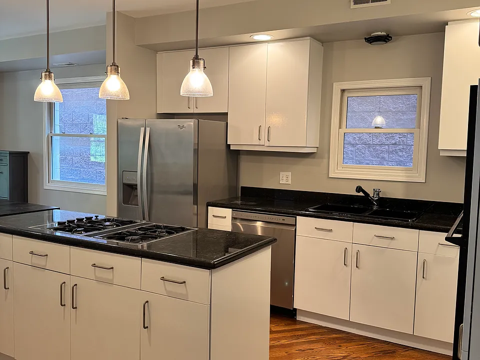 Open-concept kitchen layout with abundant cabinet storage and modern pendant lighting.