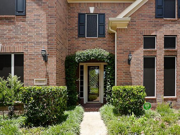 Welcome your friends & family to your new home on this beautiful covered front porch complete with a wood stained and leaded glass front door with side lights and brick flooring and beautifully lit by coach lanterns.