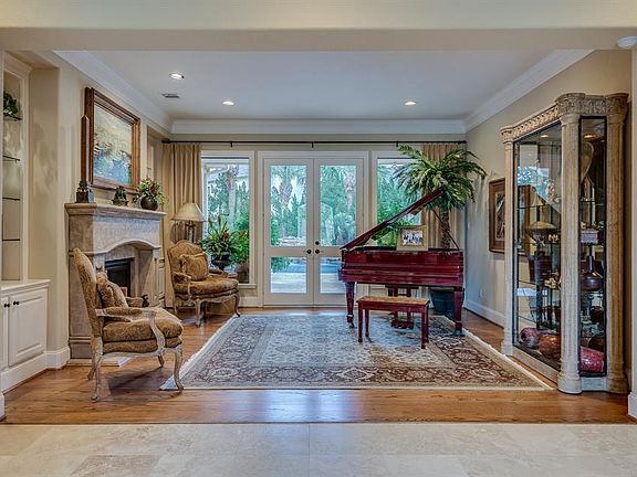 INSIDE THE DOUBLE DOORS, YOU ARE GREETED WITH THE FORMAL LIVING ROOM WITH WIDE PLANK SOLID OAK FLOORS, CAST STONE FIREPLACE, CUSTOM BUILT-INS AND FRENCH DOORS THAT TAKE YOU TO THE BACKYARD ENTERTAINING AREA.