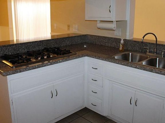 Cute kitchen with white cabinets, black appliances and granite countertops!