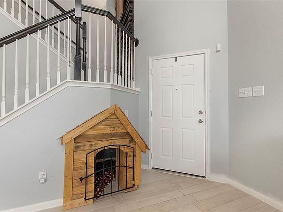 entryway with a cute dog house under the stairs for your pooch!