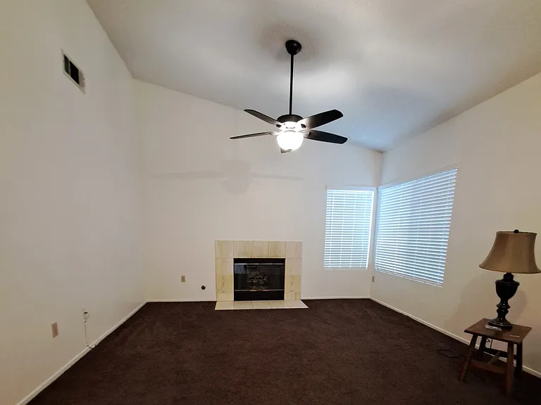 Living room with vaulted ceilings, fireplace and a ceiling fan to keep you comfortable.