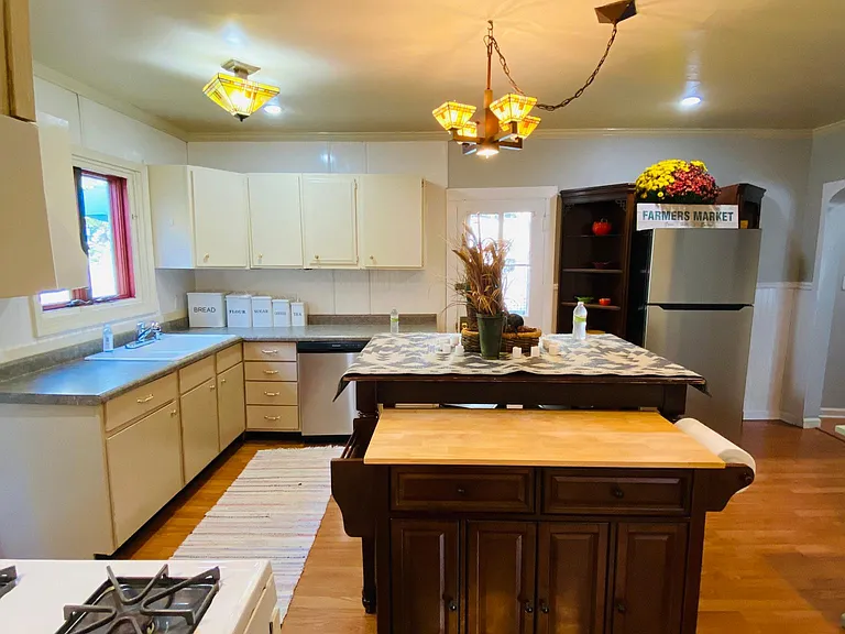 The kitchen triangle sink, dishwasher, gas stove, and refrigerator with versatile prep spaces, dining, and seating.