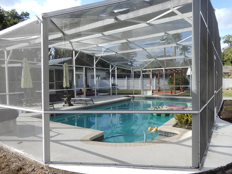 Large Screened pool with solar heating panels mounted on roof to heat the water when needed.