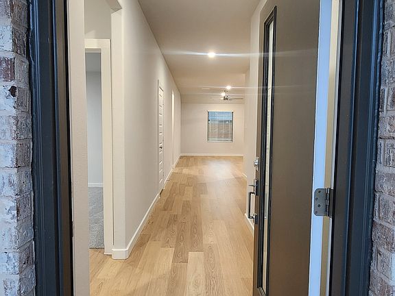 Welcoming front entry with modern design and bright open hallway leading into the home.