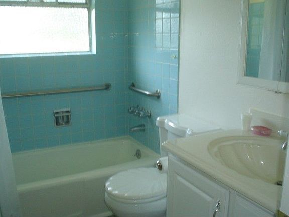 Tiled tub surround in bathroom.
