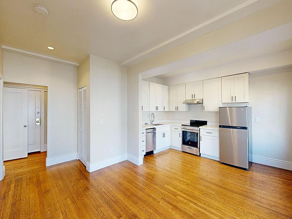 Spacious living room with a wood-like flooring and a view of the kitchen
