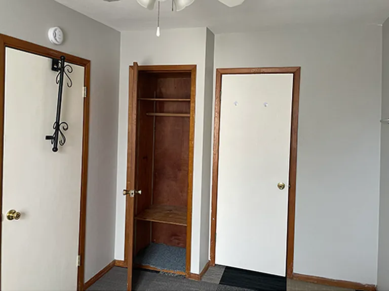 Small closet in BR. Door on right leads to bathroom. Door on left opens to kitchen
