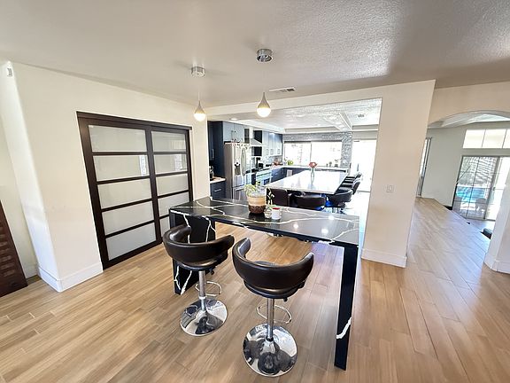 Kitchen featuring arched walkways, stainless steel fridge healthy amount of natural light.
