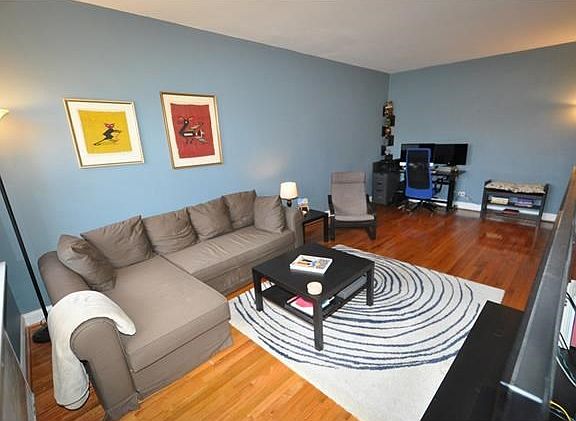 The large sunny, sunken living room has Eastern Exposures and refinished hardwood floors.