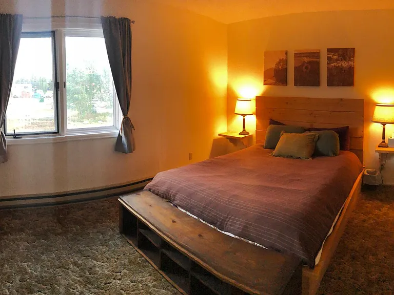 Upstairs South bedroom- bed frame, nightstands, footboard bench, lamps, and curtains provided