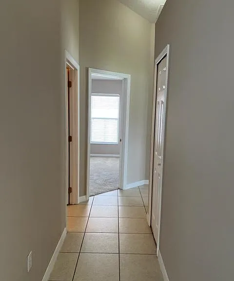 Hall (from the family room) to the guest bath on the left and the three guest rooms